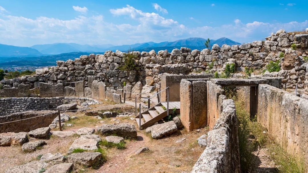 Ancient ruins of Mycenae with stone walls and mountainous backdrop, part of Nafplio-Mycenae-Epidaurus tour.