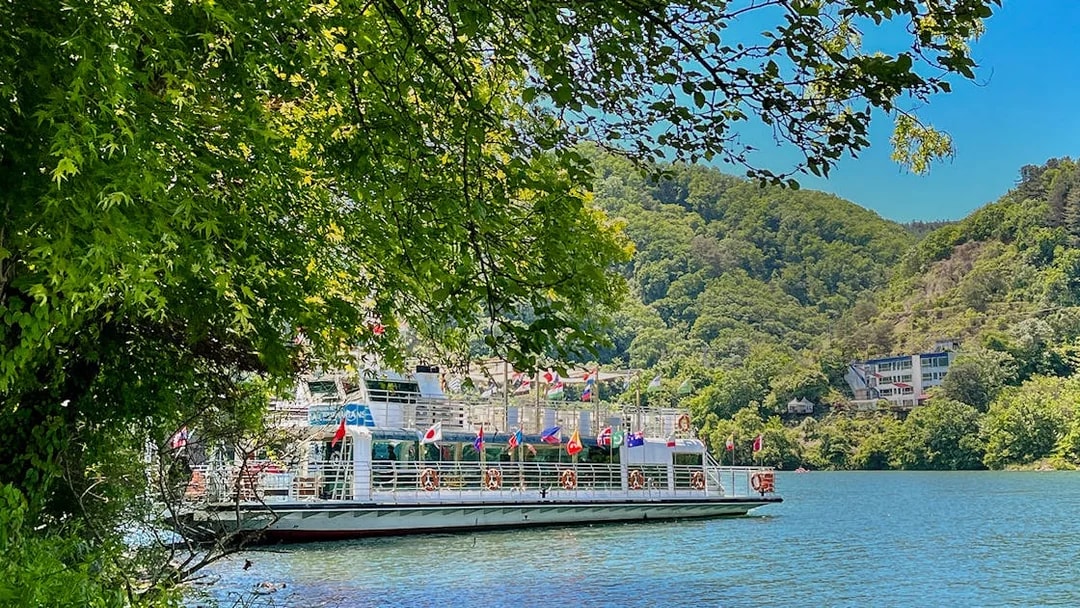 Ferry on the water surrounded by trees and hills in Nami Island, South Korea.
