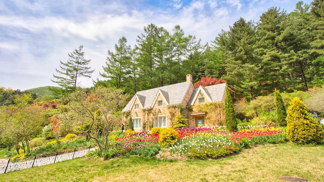 Stone cottage with tulip gardens and trees near Gapyeong, South Korea.