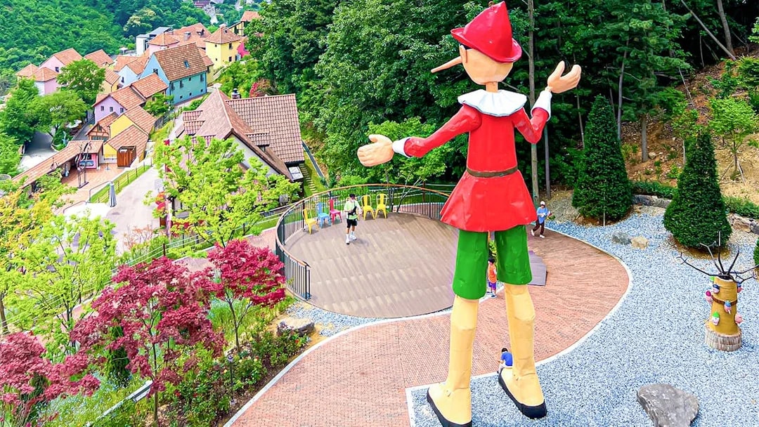 Large Pinocchio statue overlooking colorful houses in Italian Village, South Korea.