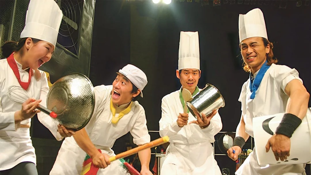 Performers in chef outfits playing kitchen instruments at Seoul Myeongdong Nanta Musical Show.