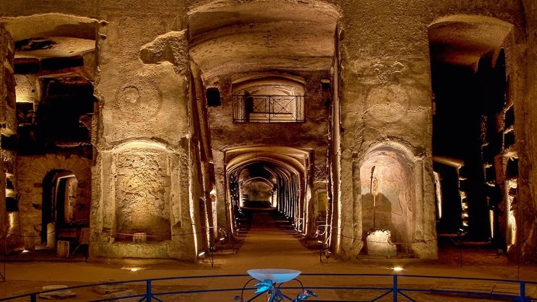 Catacombs of San Gennaro, ancient underground burial site with illuminated arches and passageways.