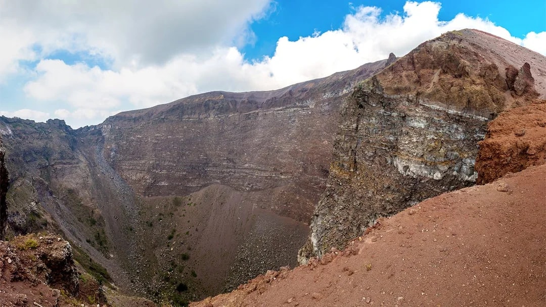 Crater of Mount Vesuvius in Naples, Italy, with rocky terrain and clear sky.