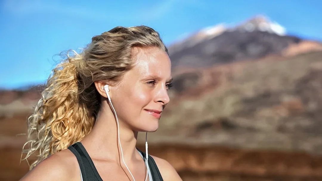 Person with earphones enjoying Mount Vesuvius view in Naples.