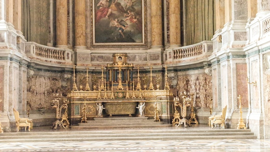 Royal Palace of Caserta ornate interior with gilded altar and marble columns.