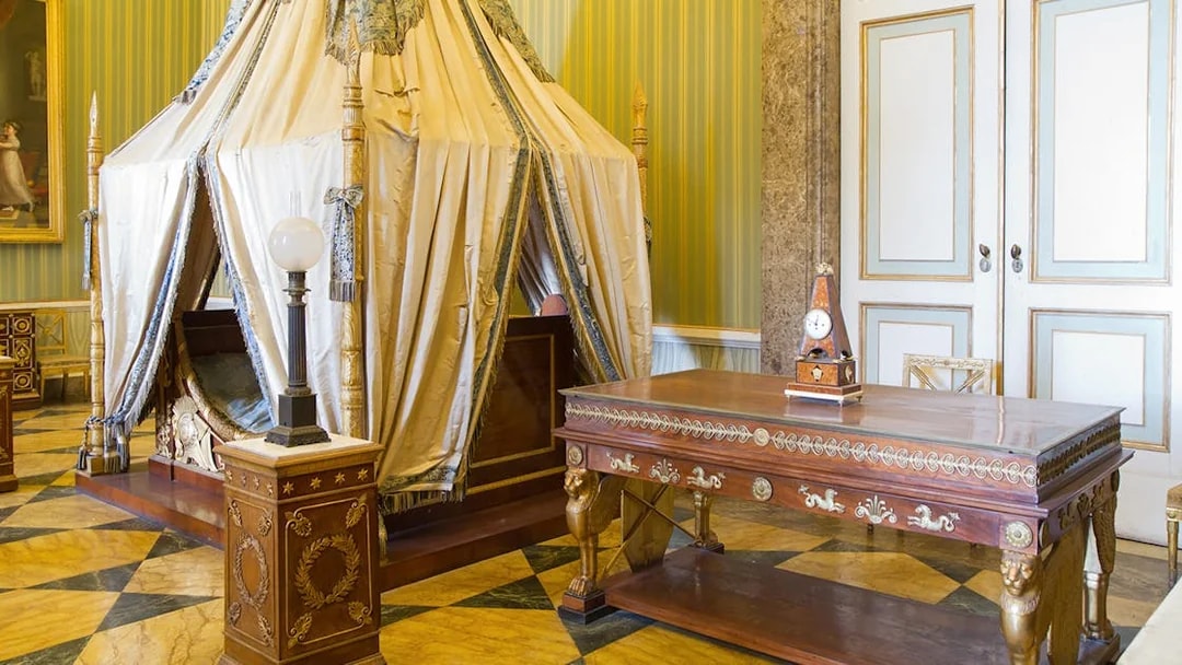 Royal Palace of Caserta bedroom with ornate canopy bed and antique furniture.