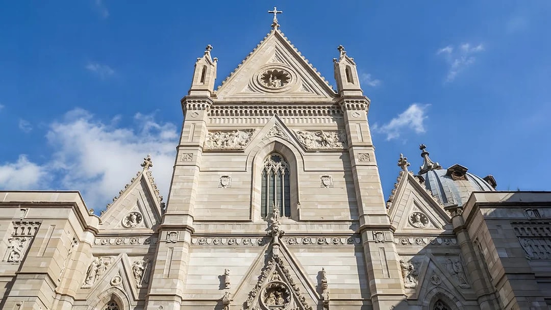 Sansevero Chapel facade with intricate sculptures and architectural details under a blue sky.