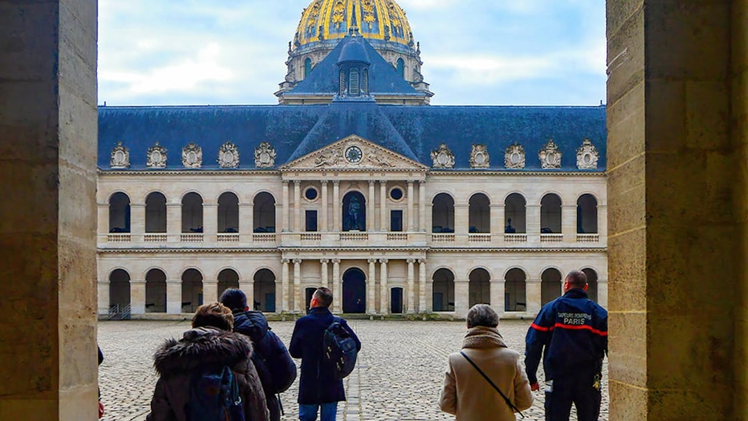 Visitors at Les Invalides courtyard with the Dome in Paris on Napoleon's Legacy Tour.