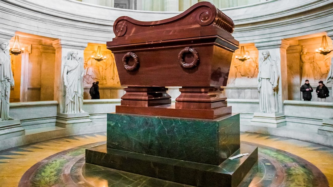 Tomb of Napoleon in Les Invalides, Paris, surrounded by statues and ornate architecture.
