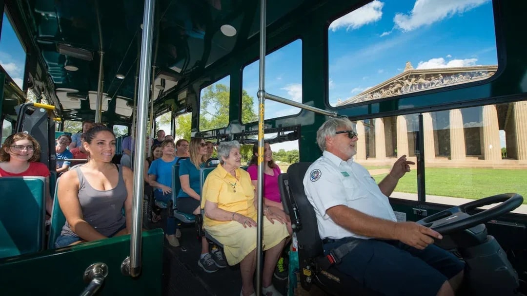 Passengers on Nashville hop-on hop-off trolley tour passing the Parthenon replica.