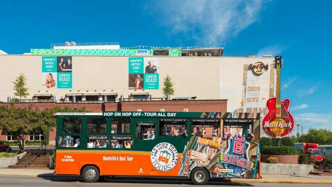 Nashville Old Town Trolley in front of Hard Rock Cafe with passengers on board.