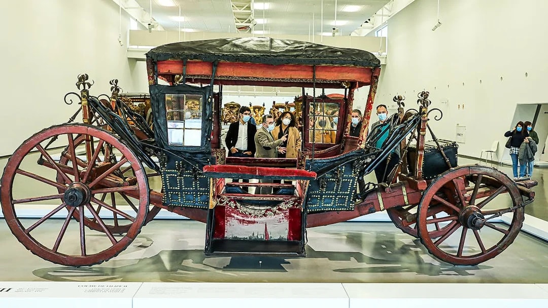 Visitors viewing a historic coach at the National Coach Museum.