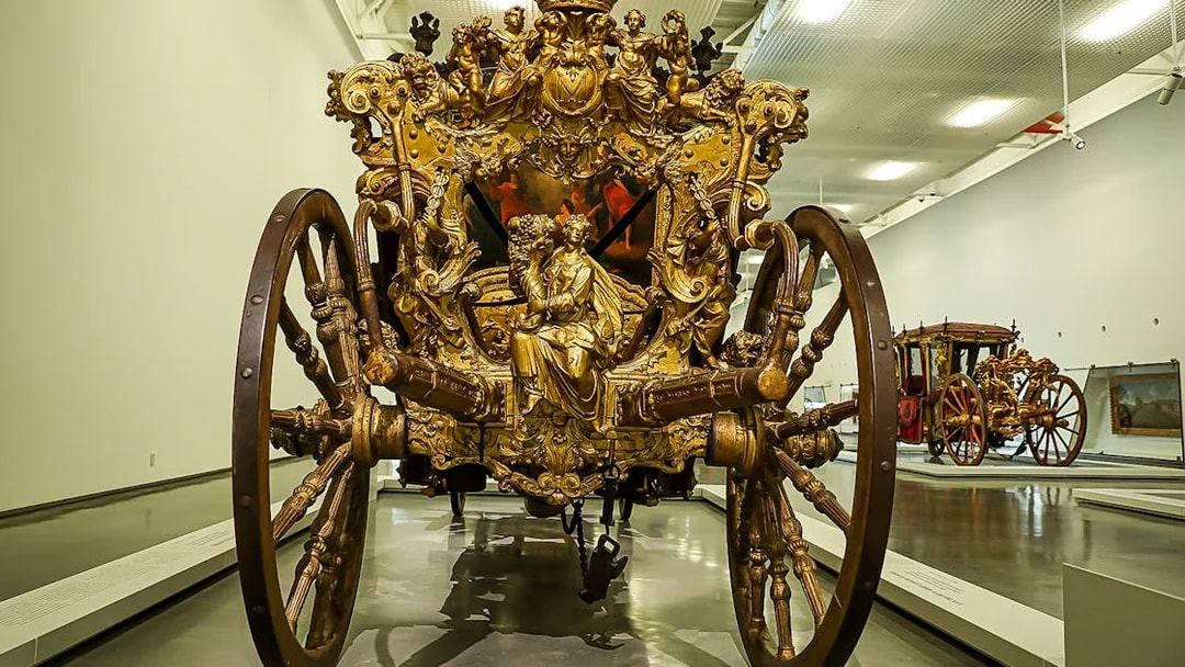 Ornate golden carriage on display at the National Coach Museum in Lisbon.