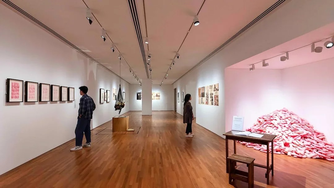 Visitors viewing art exhibits inside National Gallery Singapore.