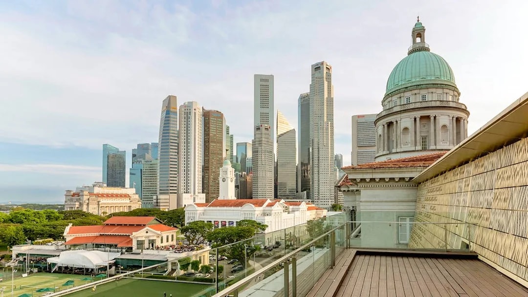 Rooftop view from National Gallery Singapore with city skyline and historic dome.