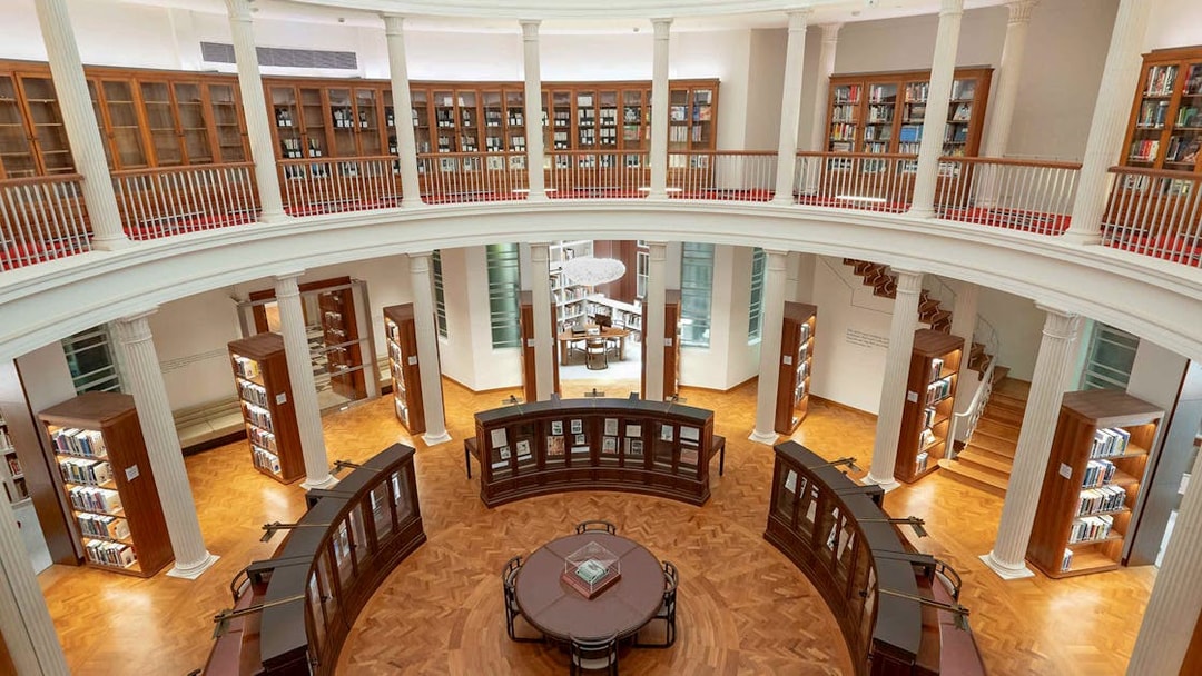Library interior with bookshelves and reading table, National Gallery Singapore.