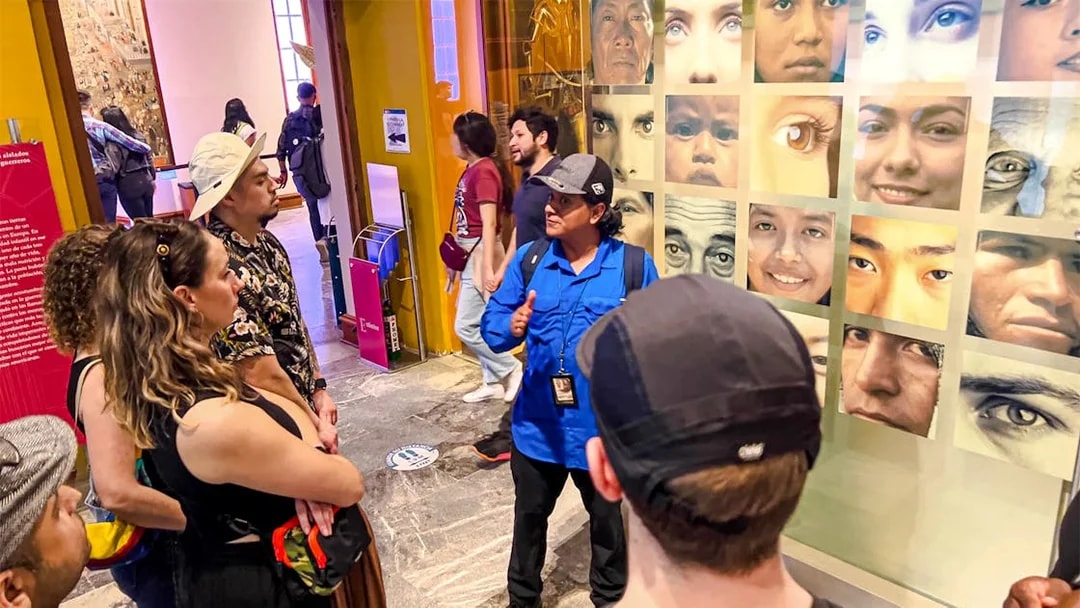 Visitors listening to a guide at the Anthropology Museum in Mexico City.
