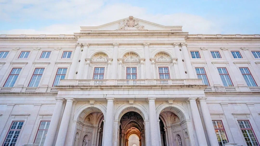 National Palace of Ajuda facade with grand arches and ornate windows in Lisbon, Portugal.