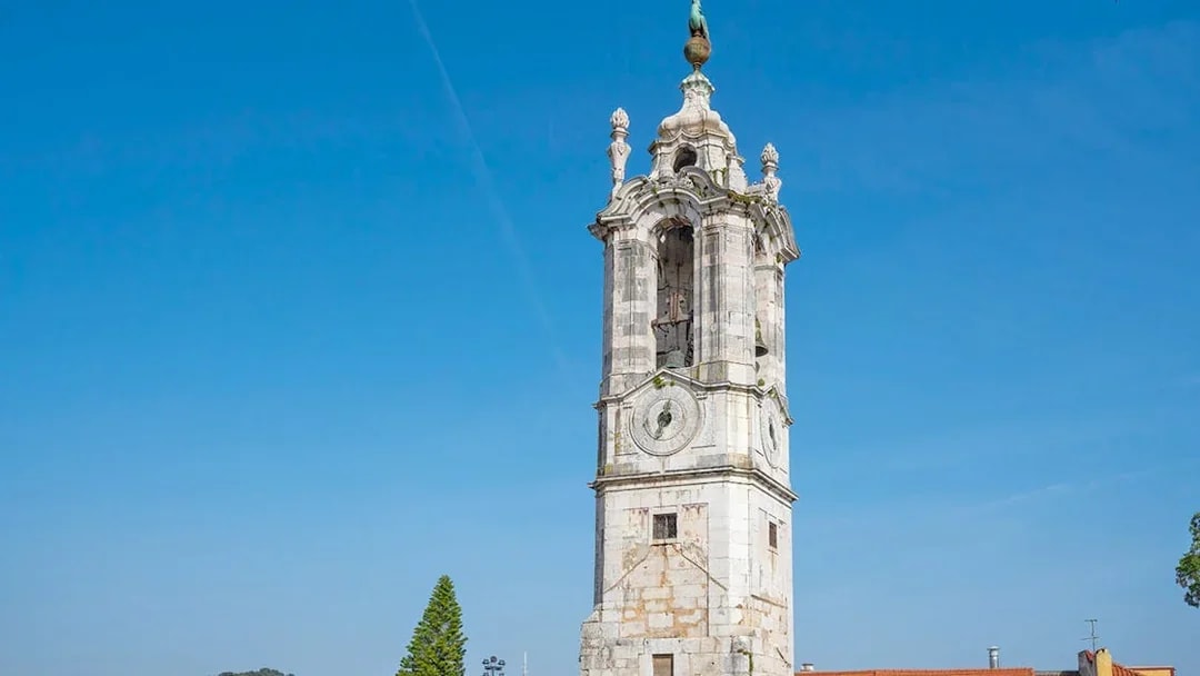 Clock tower at the National Palace of Ajuda, Lisbon, under a clear blue sky.