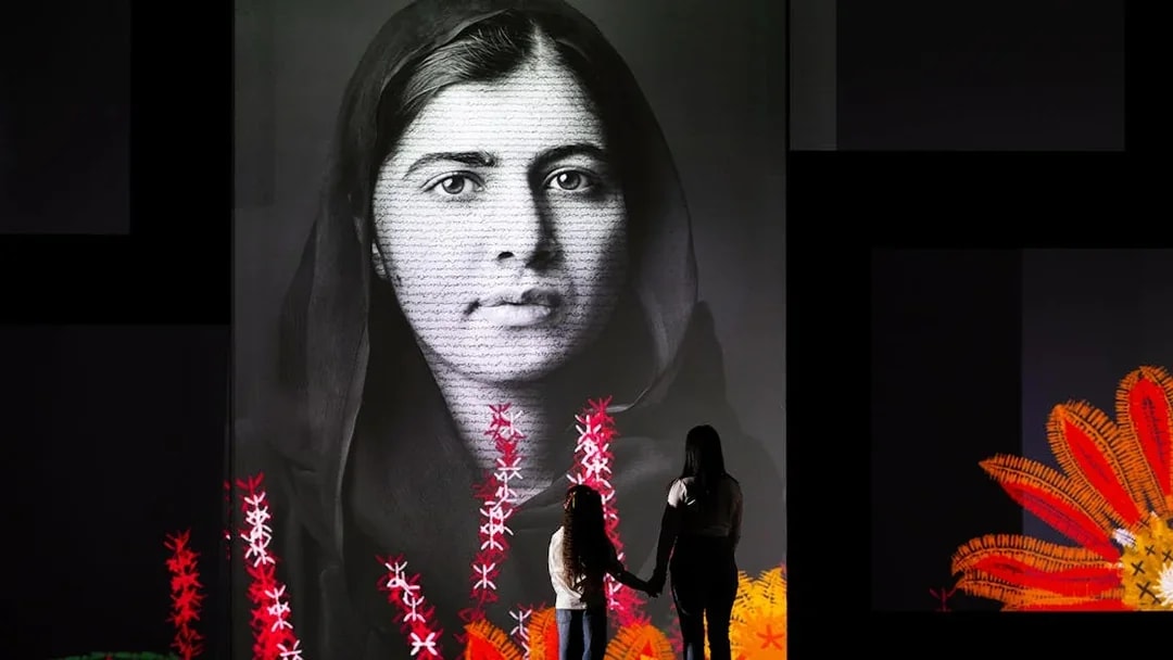 Visitors viewing a large portrait at the Frameless National Portrait Gallery Exhibition.