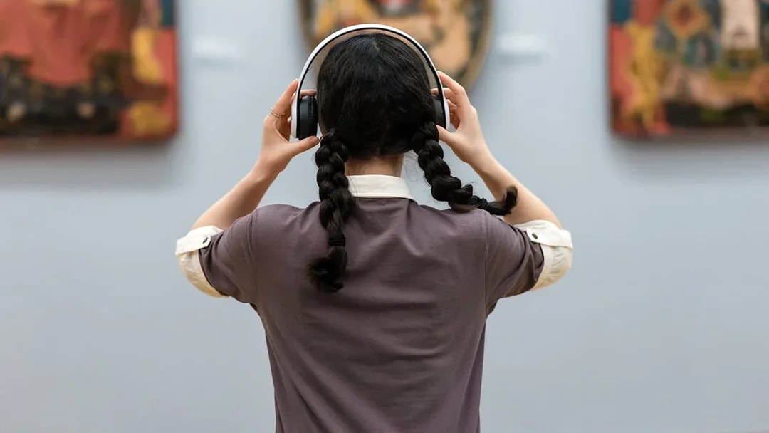 Visitor using audio guide at National Sintra Palace art exhibit.