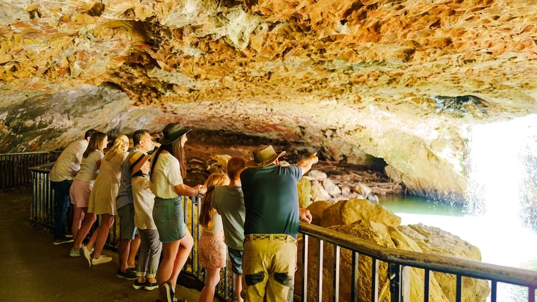 Visitors observing waterfall inside Natural Bridge cave, Springbrook National Park.