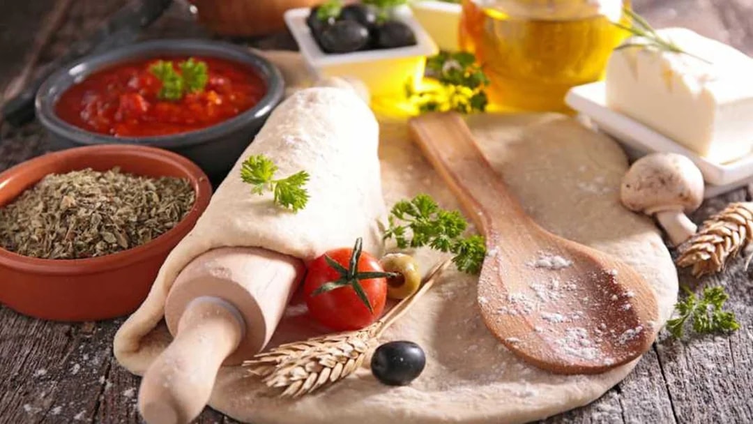 Pizza dough with fresh ingredients at Neapolitan cooking school in Sorrento.