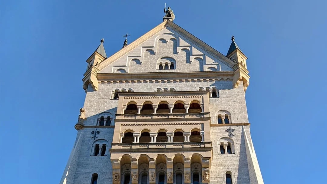Neuschwanstein Castle facade close-up showing detailed stonework and arched windows.