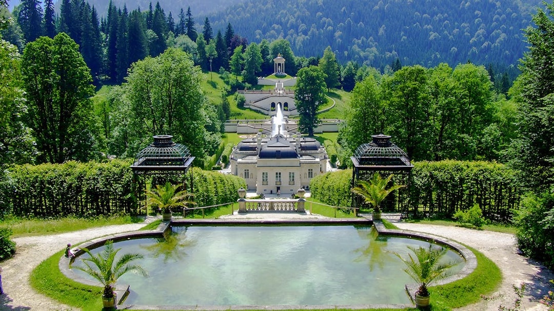 Linderhof Palace gardens with fountains and lush greenery in Bavaria, Germany.