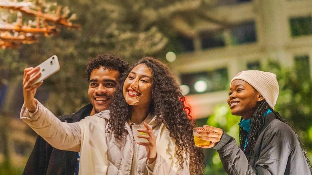 Visitors enjoying drinks and taking a selfie at New York Botanical Gardens.