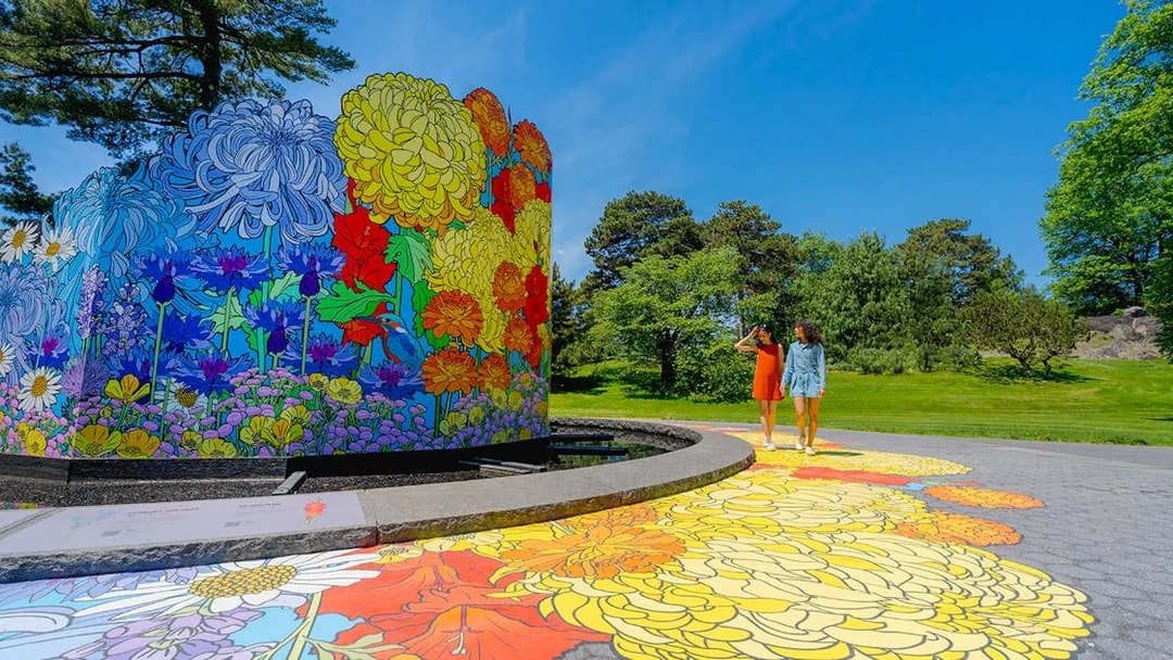 Guests walking by colorful floral mural at New York Botanical Garden.