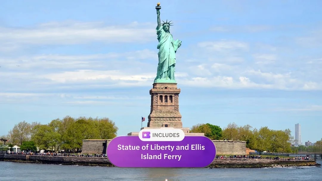 Statue of Liberty with Ellis Island ferry in New York Harbor.