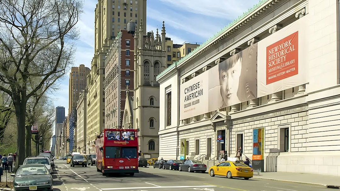 New York Historical Society building exterior with street view and tour bus.