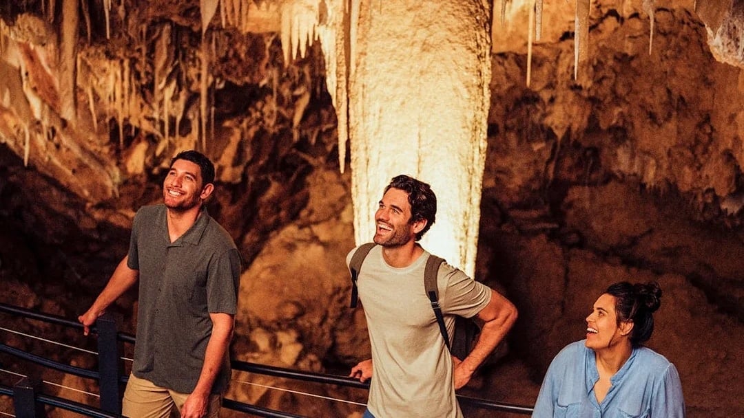 Visitors exploring stalactites in Ngilgi Cave, Australia.