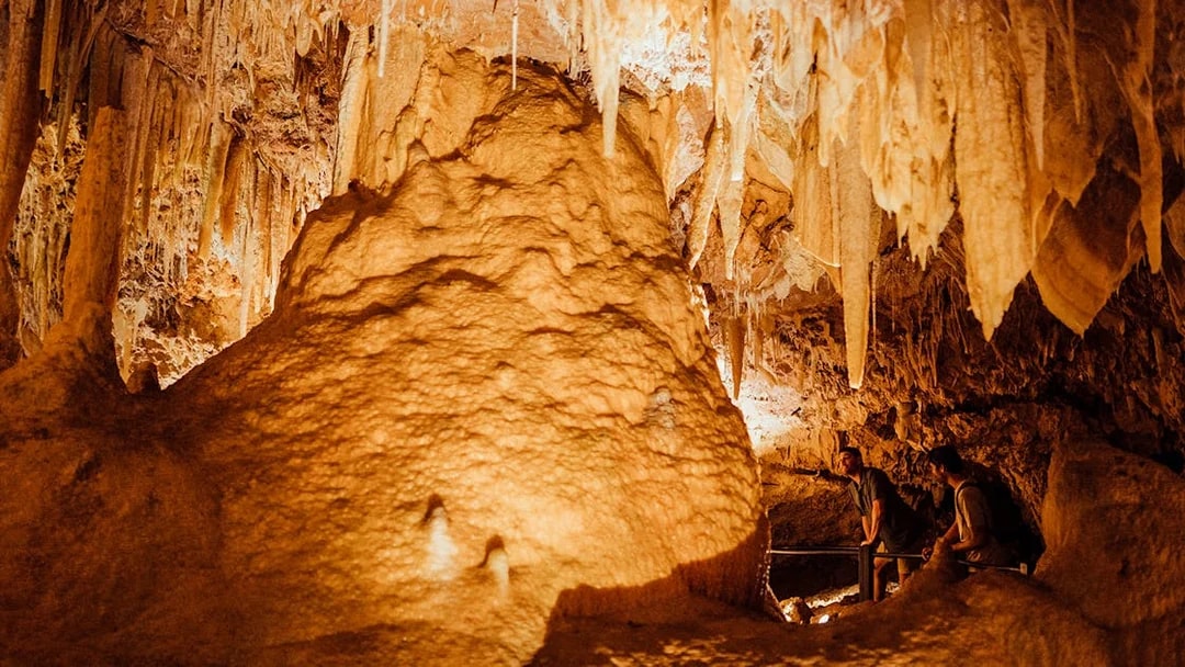 Ngilgi Cave stalactites and rock formations with visitors exploring the Ancient Lands Experience.