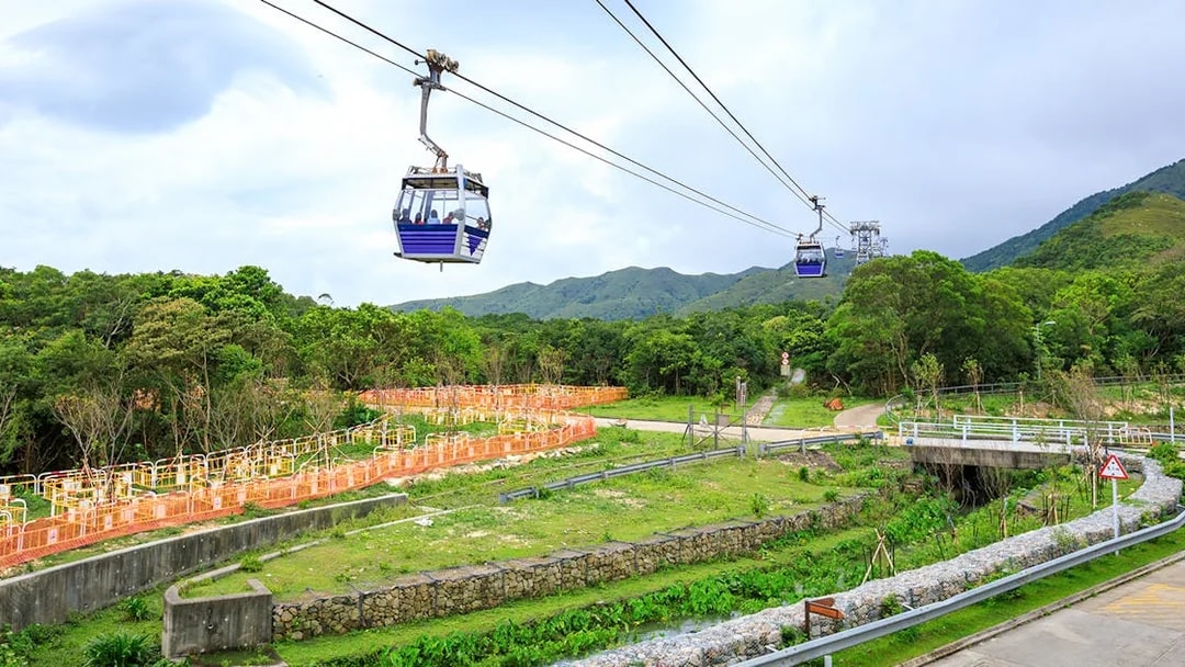 Ngong Ping Cable Car over lush landscape with mountains in the background, Hong Kong.
