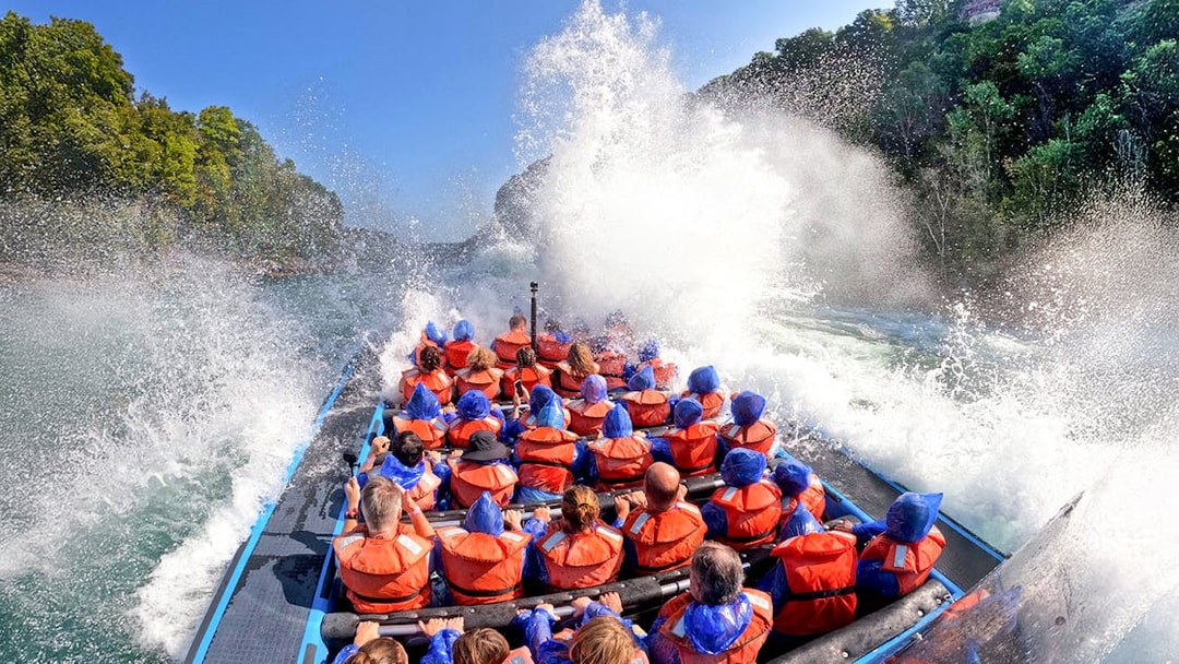 Guests on Whirlpool Jet Boat Tour in Niagara Gorge, Canada, experiencing water splashes.