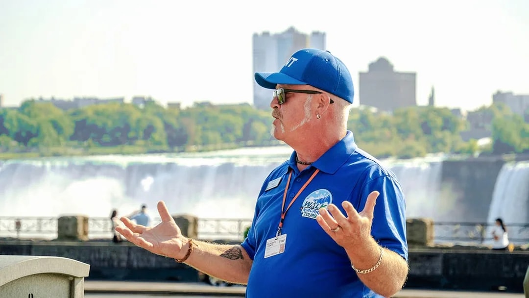 Tour guide speaking with Niagara Falls, Canada in the background.