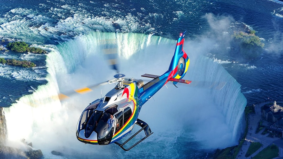 Helicopter flying over Niagara Falls during a scenic tour.