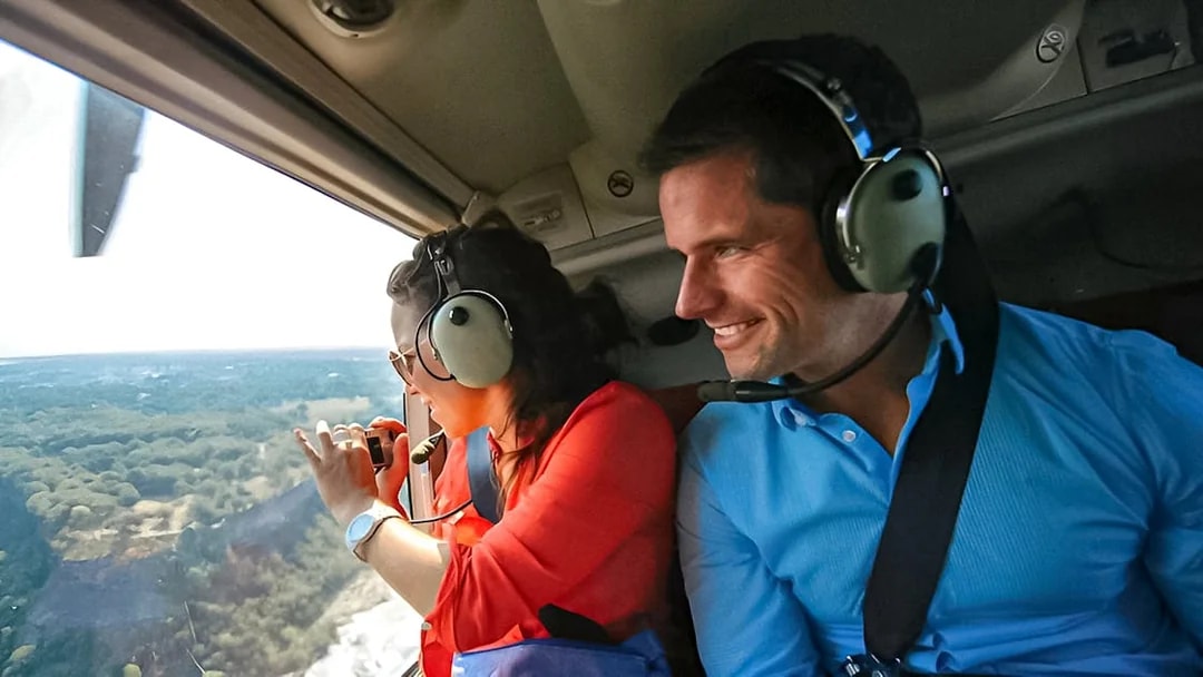 Helicopter passengers view Niagara Falls from above, capturing the scenic landscape.