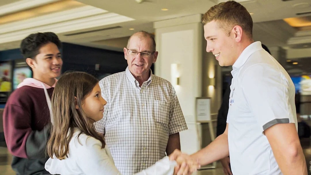 Local tour guide greeting guests in a hotel lobby.