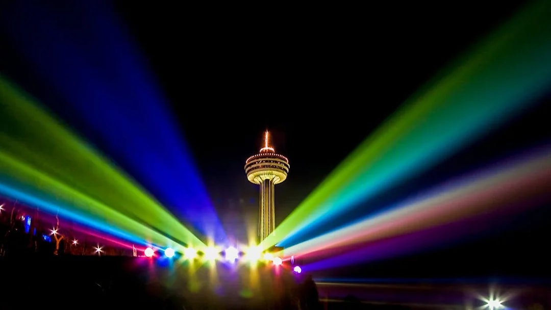 Skylon Tower in Niagara Falls illuminated with colorful lights at night.