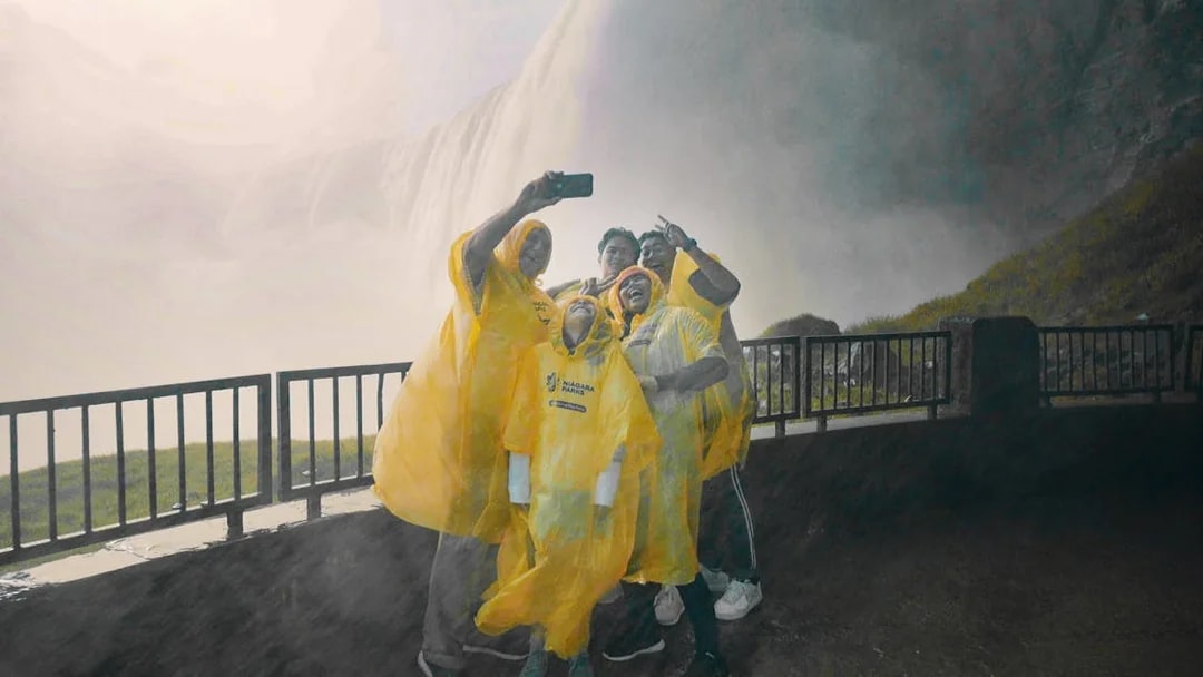 Visitors in yellow ponchos taking a selfie near Niagara Falls, Canada.