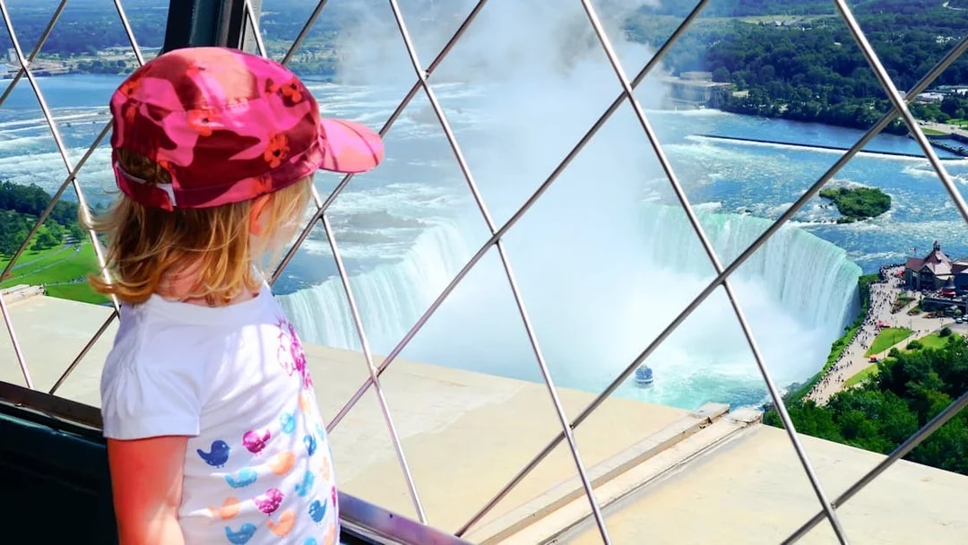 Child viewing Niagara Falls from observation deck, Canada and USA tour.