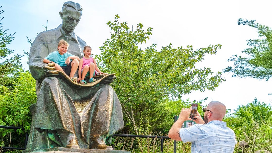 Children sitting on Nikola Tesla Monument at Niagara Falls State Park, Goat Island, New York.