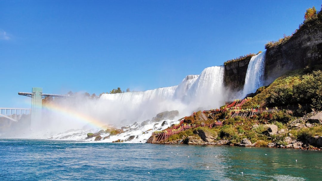 Niagara Falls with American Falls and Bridal Veil Falls, rainbow visible over water.