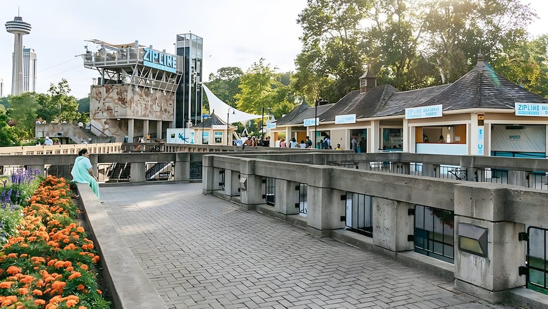 Zipline launch platform near Niagara Falls with ticket booths and observation tower.