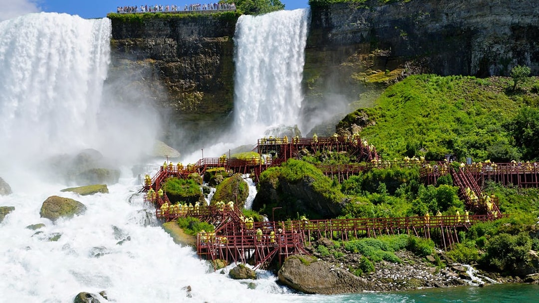 Visitors on wooden walkways at Niagara Cave of the Winds near waterfalls.