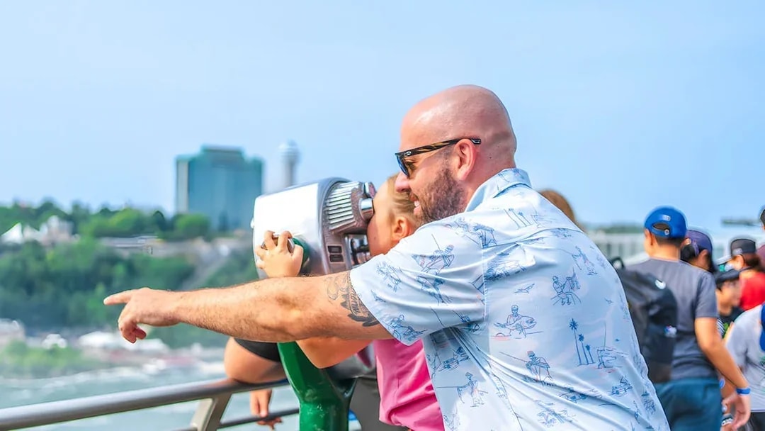 Family using binoculars at Niagara Falls observation deck.