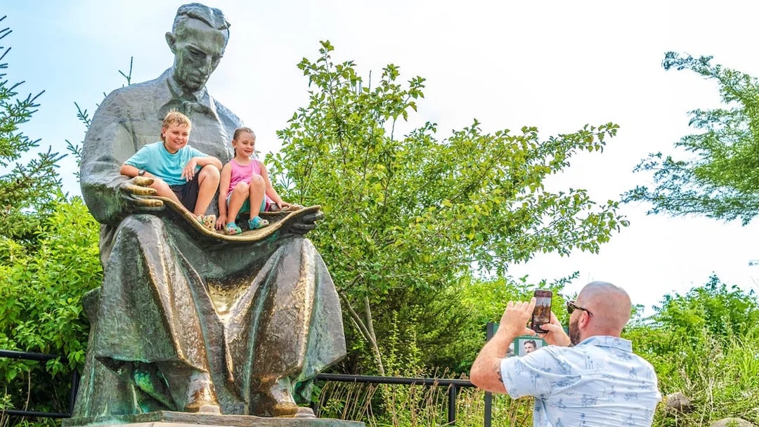 Children sitting on Nikola Tesla Monument at Niagara Falls State Park, Goat Island, New York.